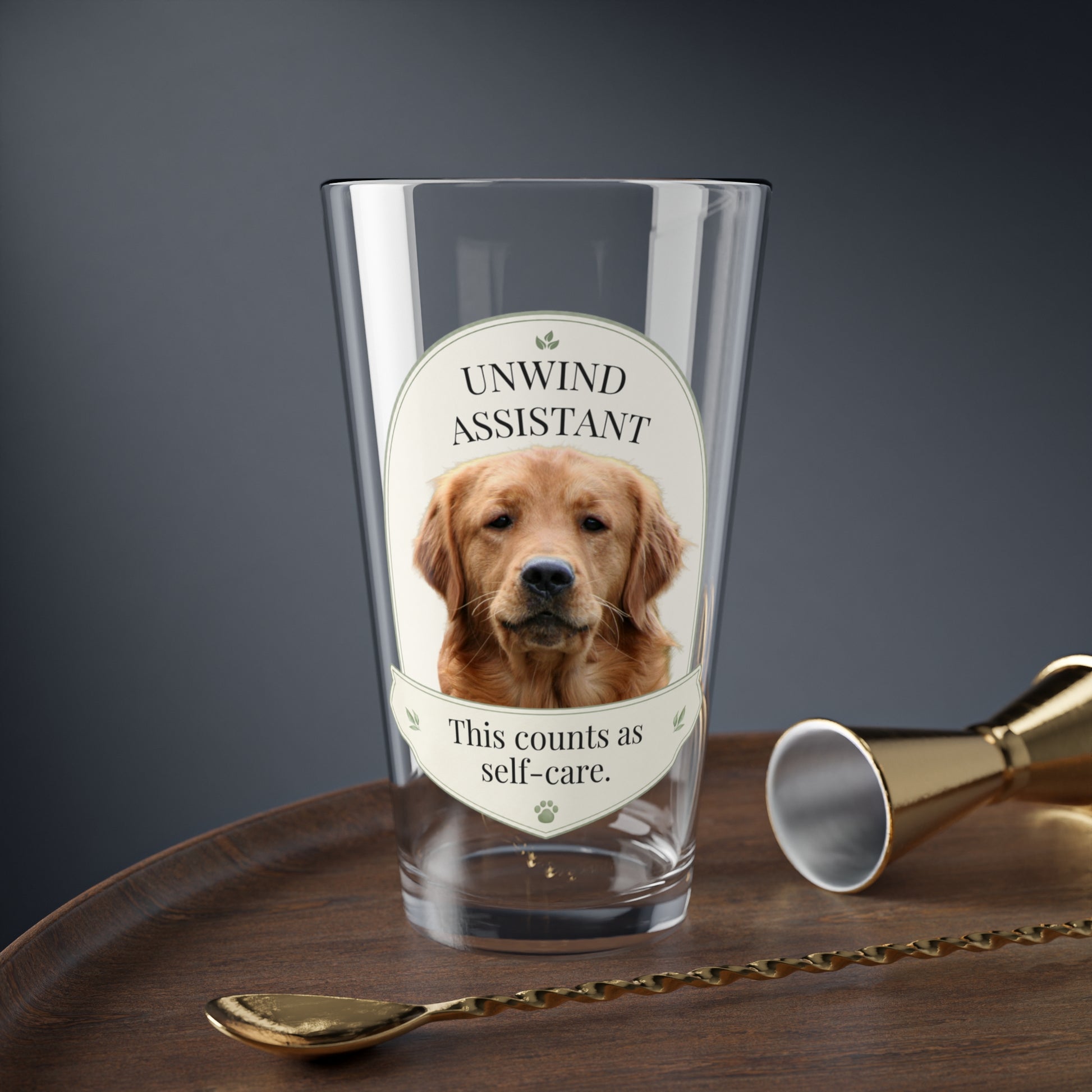 Custom pet mixing glass with Unwind Assistant golden retriever design on a bar tray with jigger and spoon
