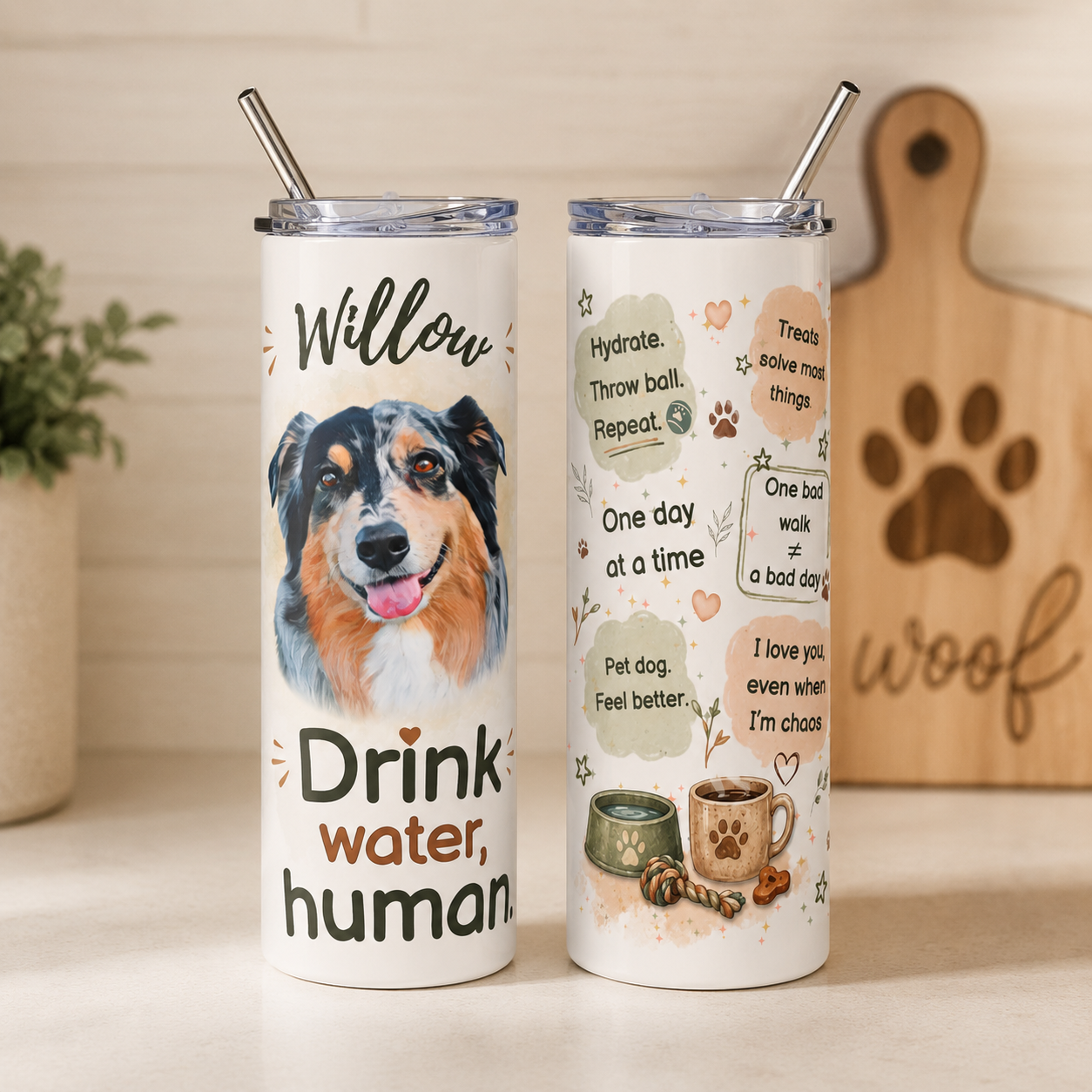 Australian Shepherd dog mom tumbler on a counter near a potted plant and a wooden 'woof' sign.