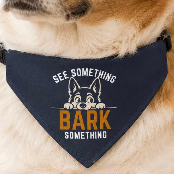 Golden dog wearing a navy "See Something Bark Something" funny dog collar bandana, close-up.