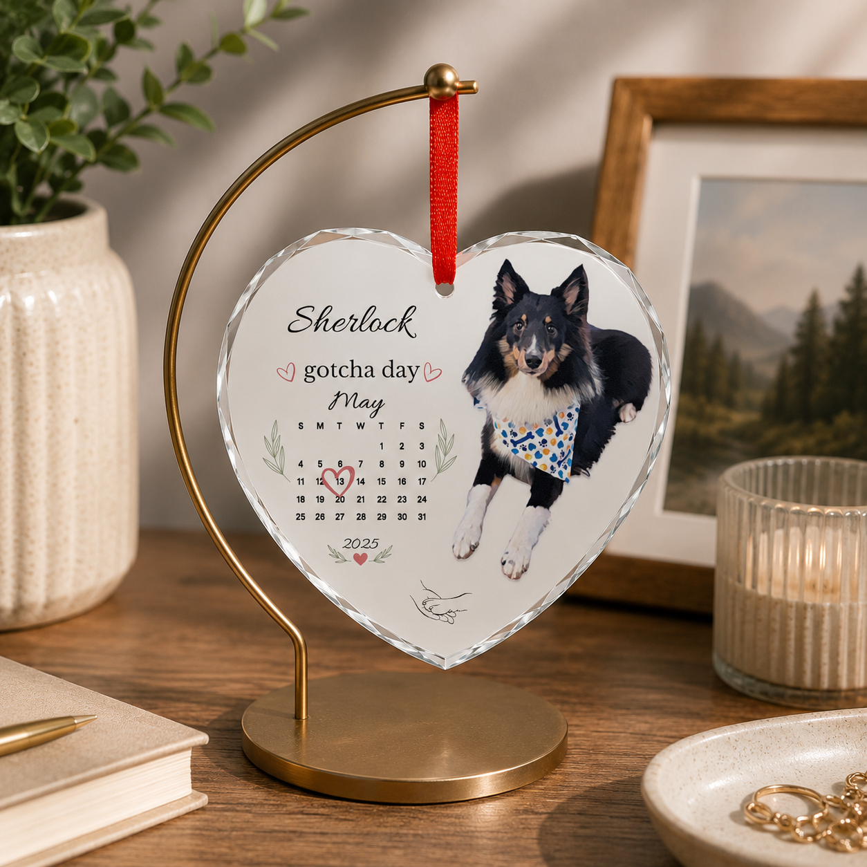 Border collie gotcha day ornament on a gold stand next to a candle and jewelry dish.