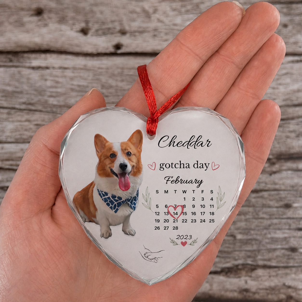 Personalized dog ornament resting flat in an open palm against a rustic wood background.
