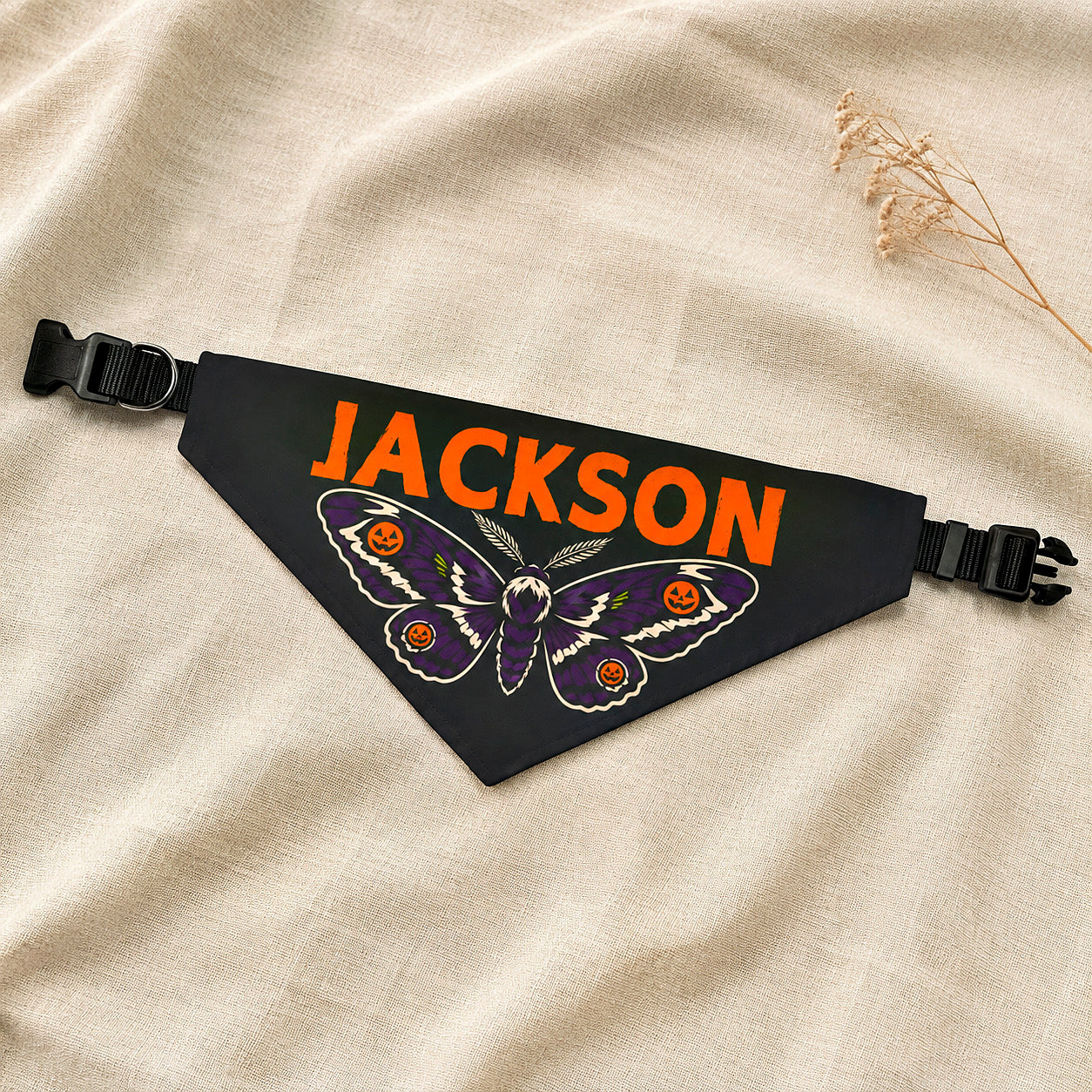 Personalized Halloween dog bandana with the name Jackson folded on a linen flat lay.